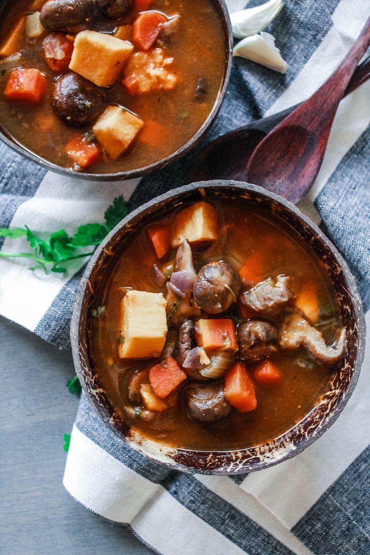 two bowls filled with stew on top of a table