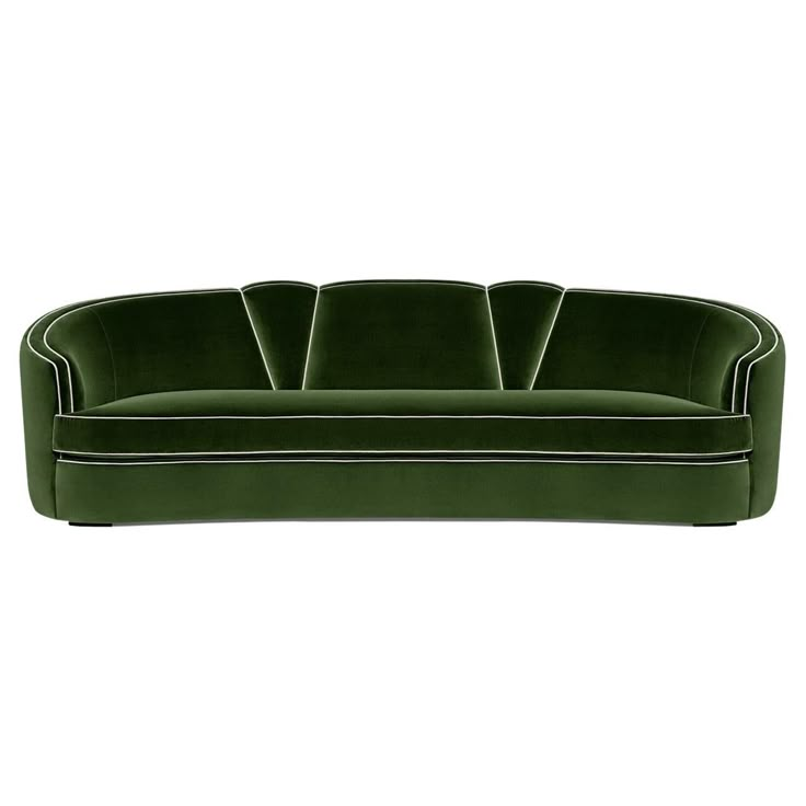 a green velvet sofa with white piping on the back and black trimmings