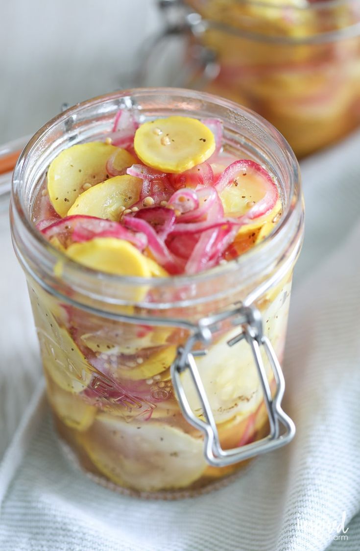 a jar filled with pickles and onions on top of a table