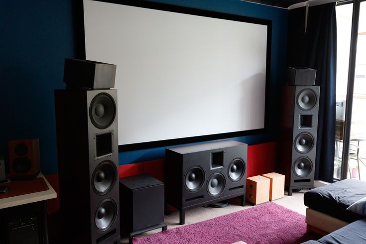 a living room with speakers and a projector screen