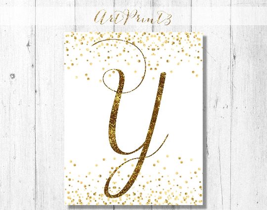 the gold glitter letter y is displayed on a white wooden background with text that reads, happy