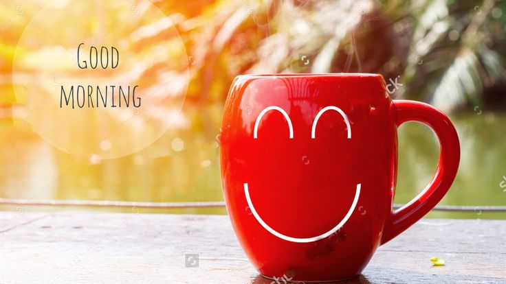 a red coffee mug with a smiley face drawn on the side sitting on a table