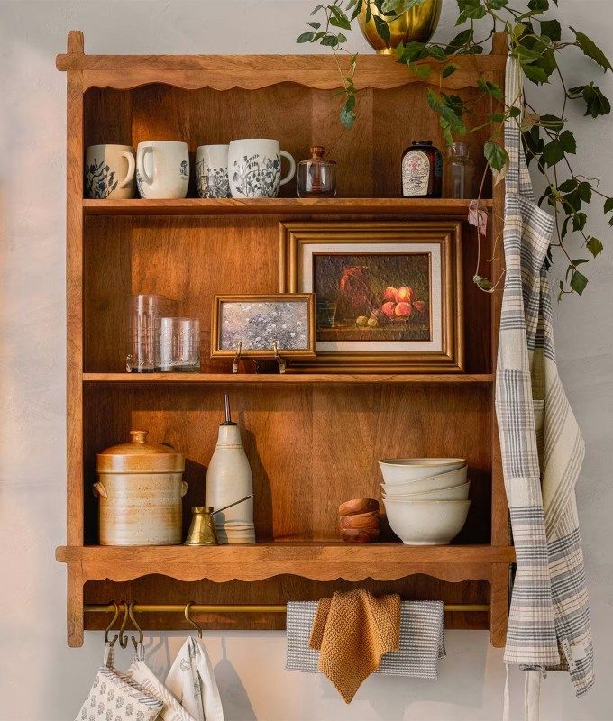 a wooden shelf filled with dishes and cups