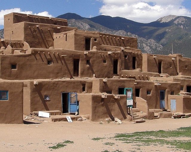 an adobe style building with mountains in the background