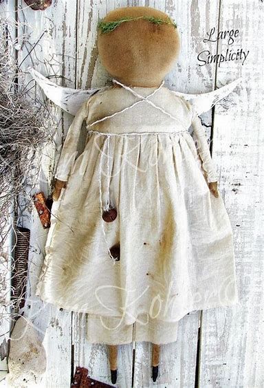 an old fashioned doll is sitting on a wooden surface