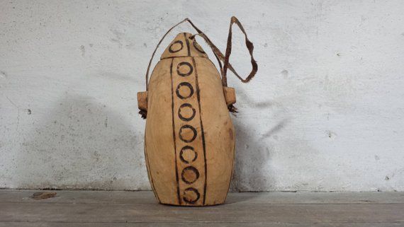 a wooden bag sitting on top of a wooden floor next to a white brick wall