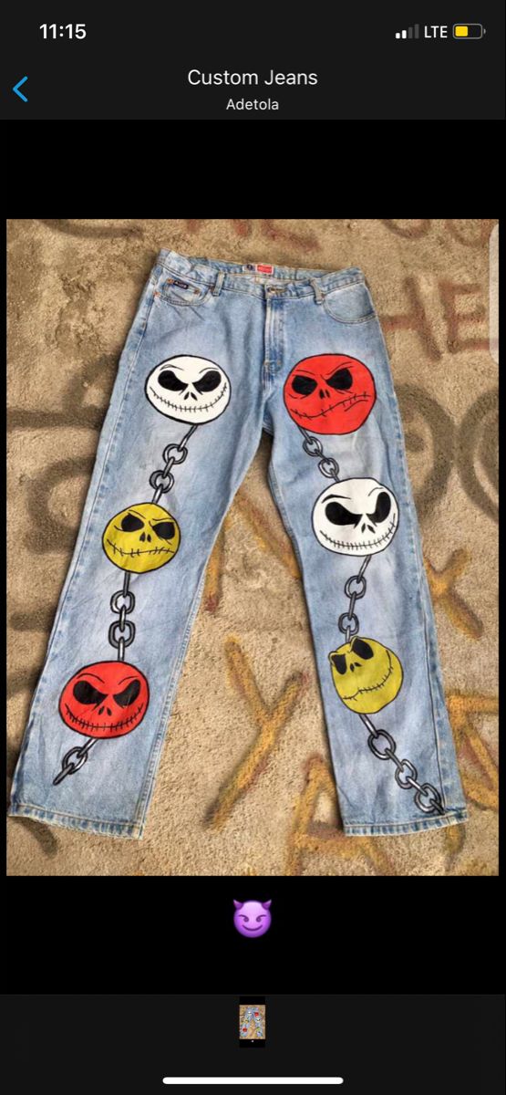 a pair of jeans with cartoon faces painted on the side and chains attached to them