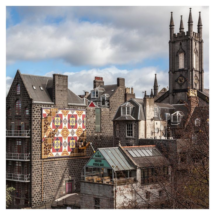 an old building with a quilt hanging on it's side