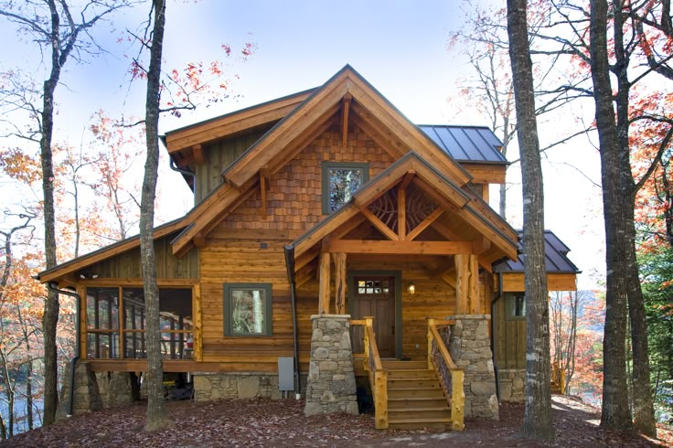 a log cabin in the woods with stairs leading up to it's front door