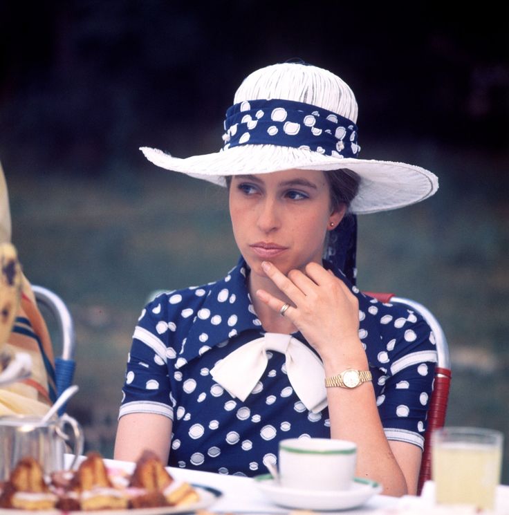 a woman wearing a polka dot hat sitting at a table