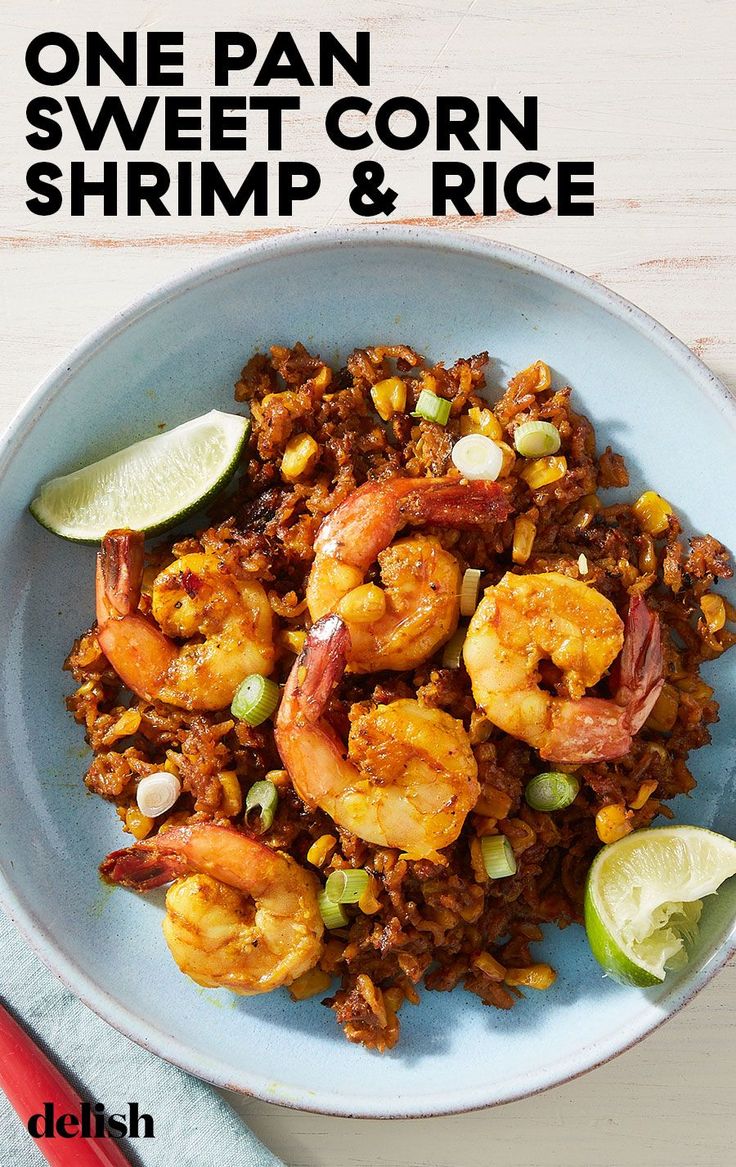 one pan sweet corn shrimp and rice on a plate with lime wedges next to it