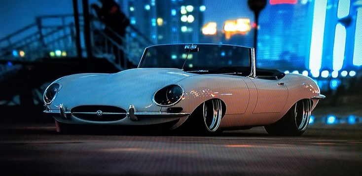 an old car is parked on the street at night