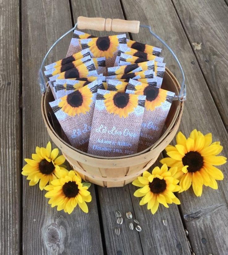 some sunflowers are sitting in a basket on a wooden table next to each other