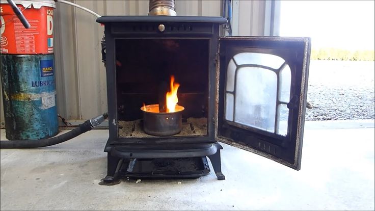 an old fashioned stove with a lit candle in it's front and side doors open