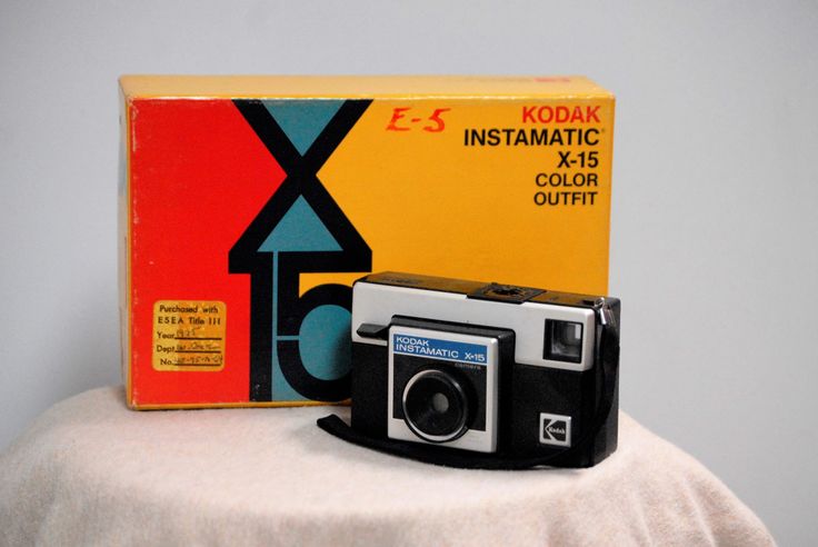 an old kodak camera sitting on top of a table next to a boxed box