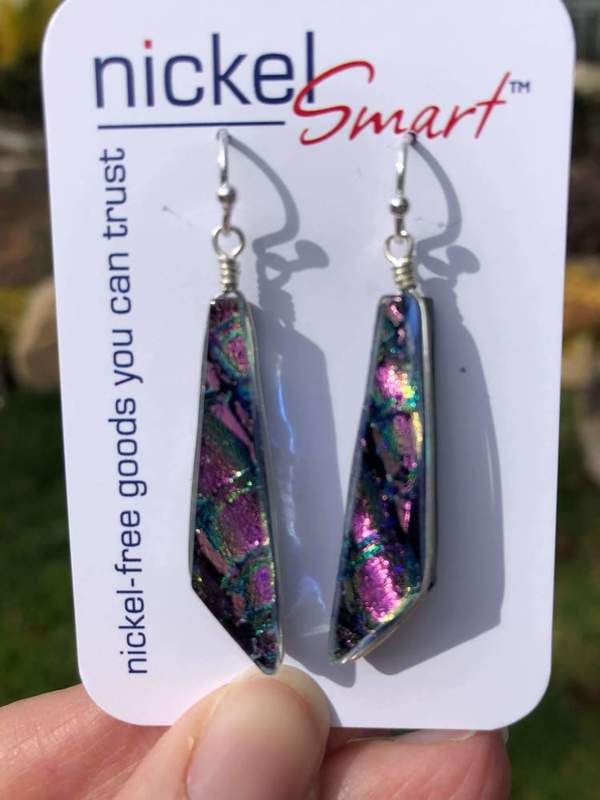 a pair of earrings is shown in front of a card that says, nice smart