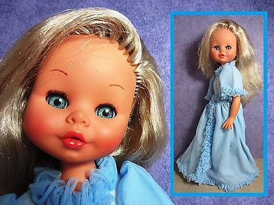 a doll with blonde hair wearing a blue dress