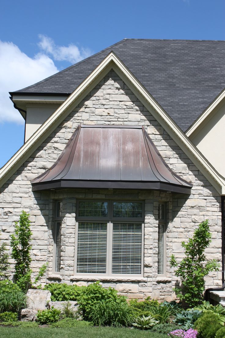 a brick house with a brown metal roof