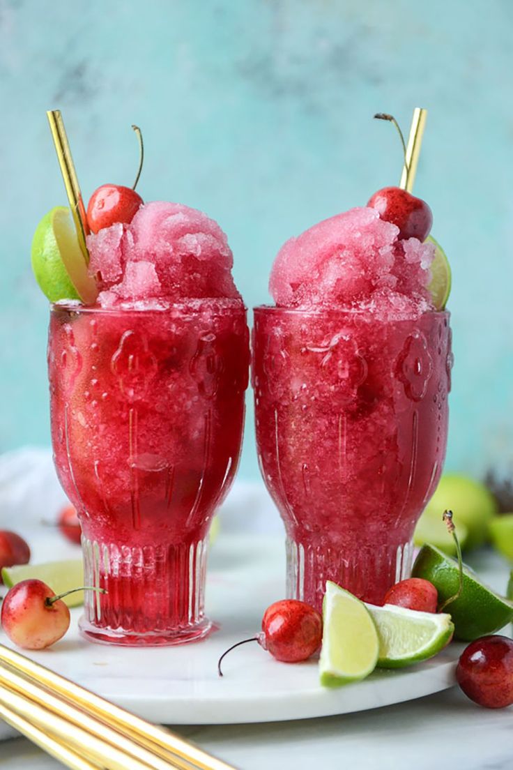 two glasses filled with ice cream and cherries on a plate next to chopsticks