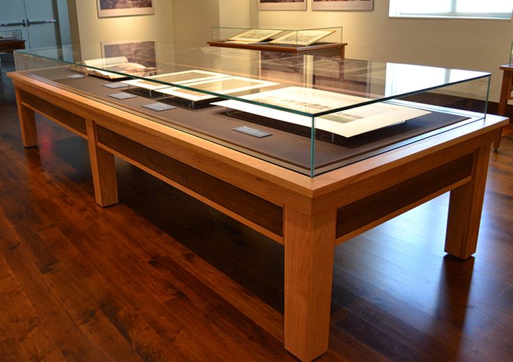 a table with some books on it in the middle of a wood floored room