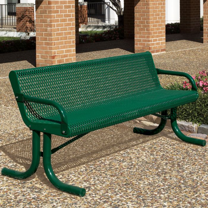 a green park bench sitting in front of a brick building