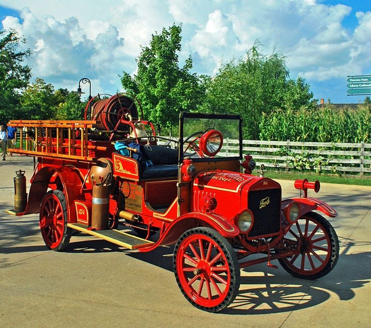 an old fashioned fire truck parked in a parking lot