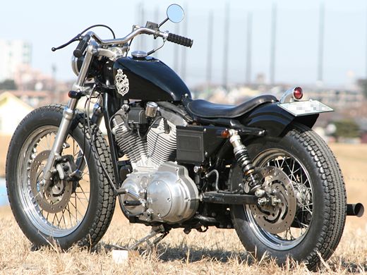 a black motorcycle parked on top of a dry grass field