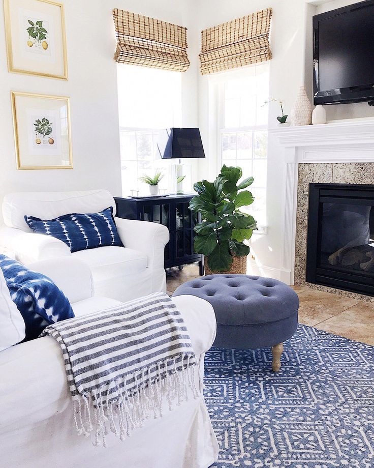 a living room with white furniture and blue rugs on the floor is featured in instagram