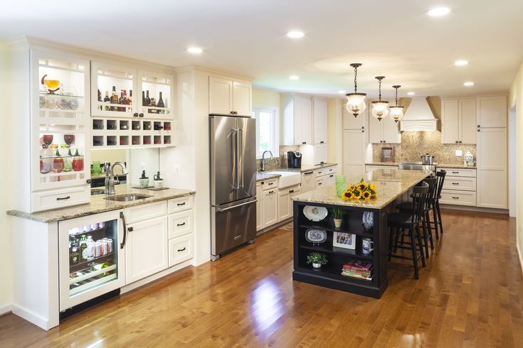 a large kitchen with white cabinets and wood floors