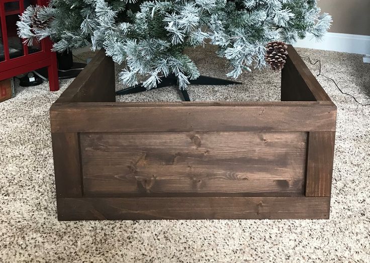 a christmas tree in a wooden box on the floor