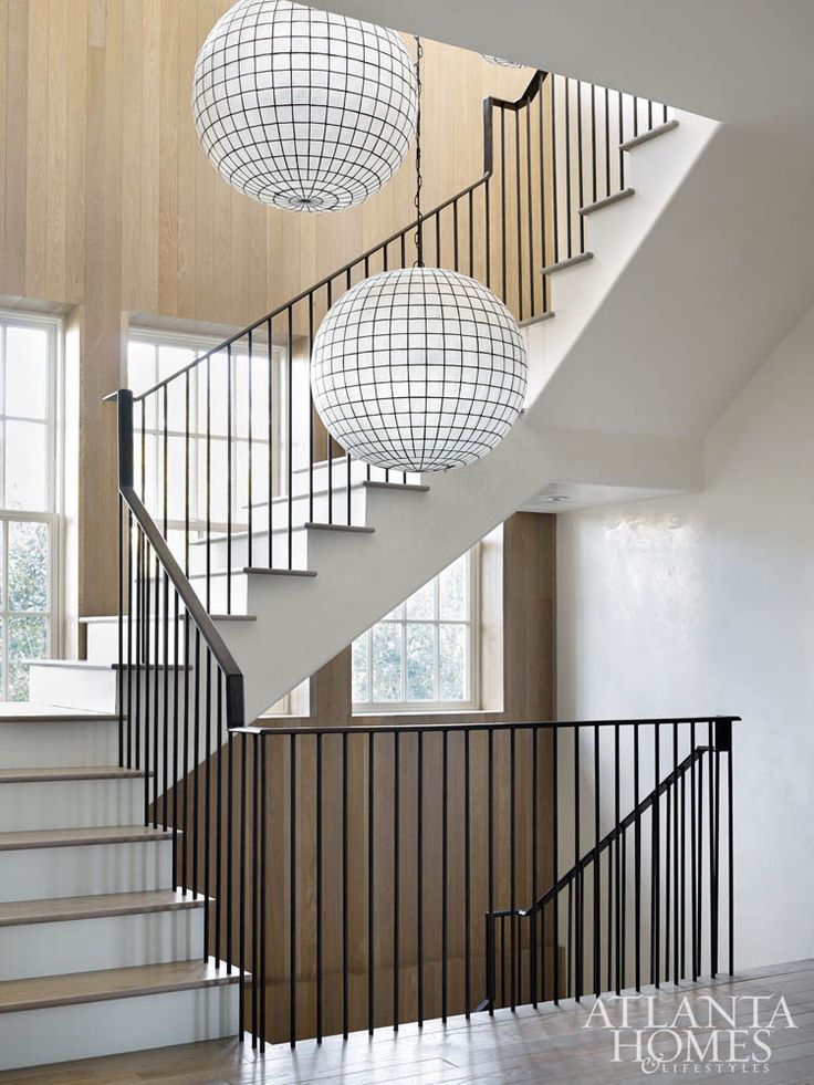 three balls hanging from the side of a stair case next to a set of stairs