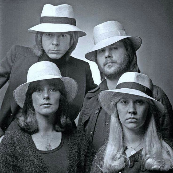 four people wearing hats posing for a photo