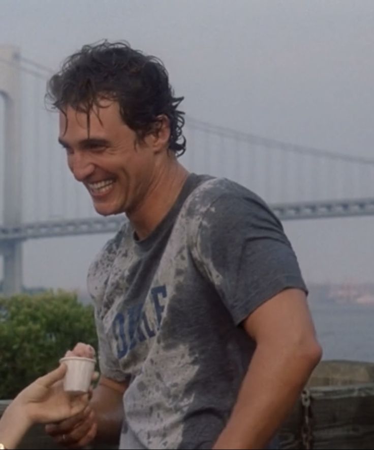 a man holding a coffee cup in front of the golden gate bridge