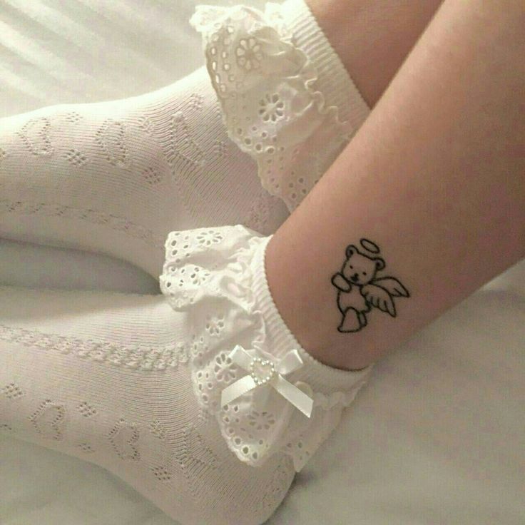 a woman's foot with a small tattoo on her left ankle and white socks