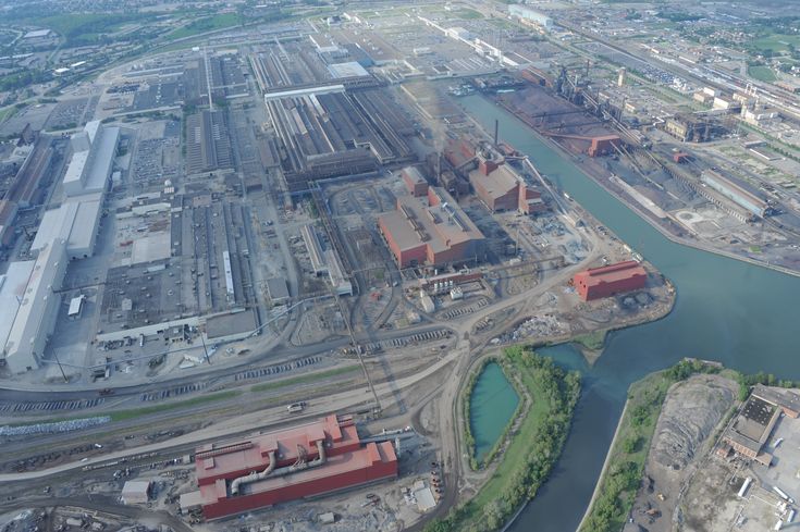 an aerial view of a large industrial area with water and buildings in the foreground