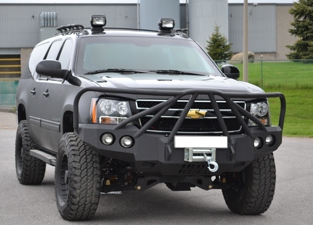 a black truck parked in front of a building with two lights on it's roof