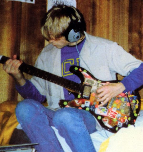 a young man wearing headphones and playing an electric guitar