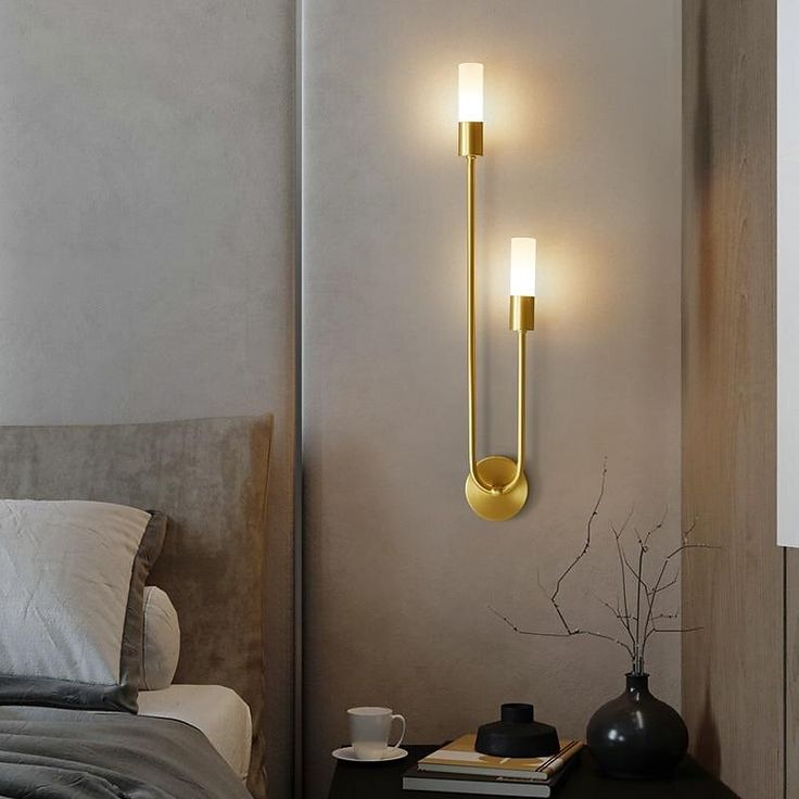 two lights on the wall above a bed