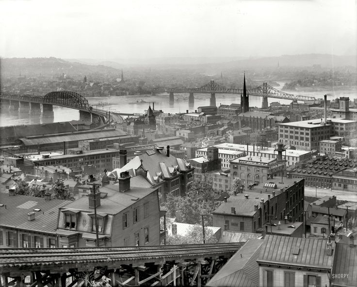 an aerial view of a city with bridges and buildings in the foreground is shown