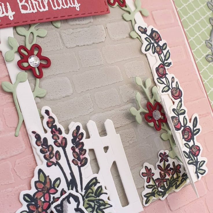 a birthday card with flowers on it and a sign that says happy birthday in front of a brick wall