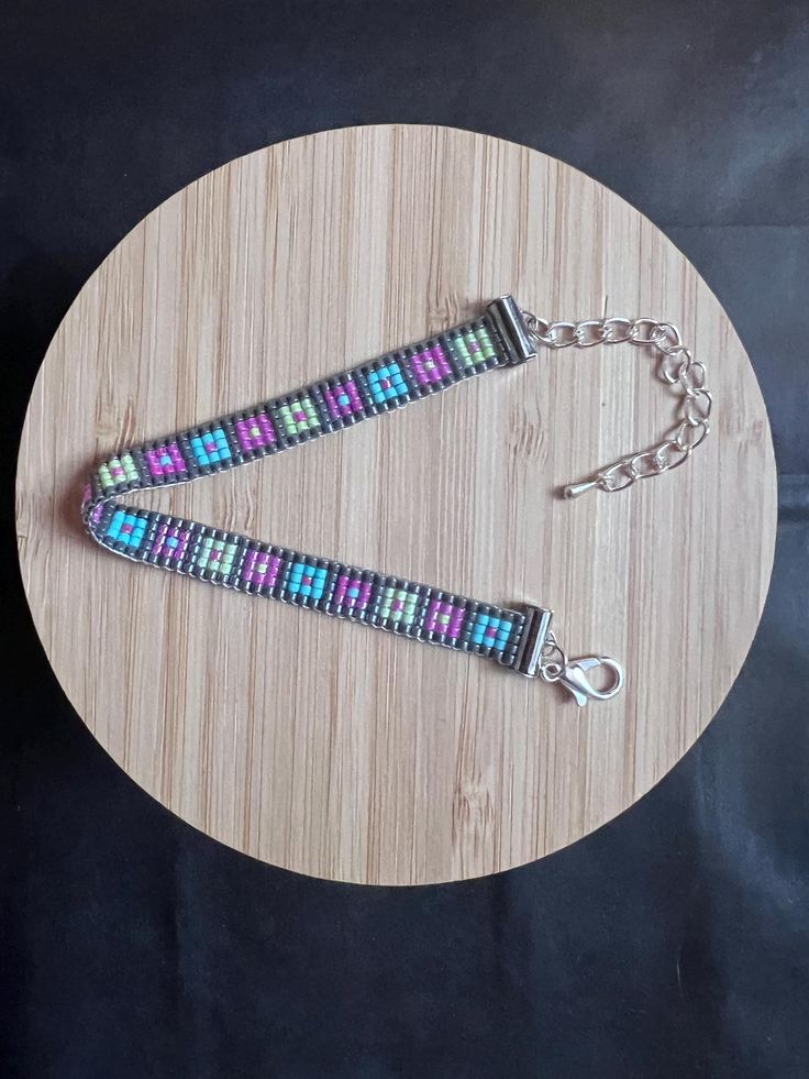 a pair of bracelets sitting on top of a wooden table next to a bottle opener