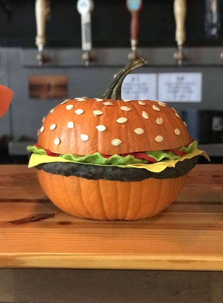 a pumpkin shaped like a hamburger sitting on top of a wooden table