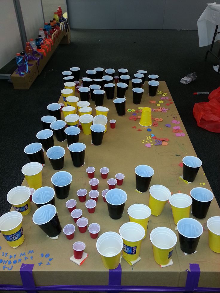 plastic cups are lined up on a table with confetti scattered around them in the background