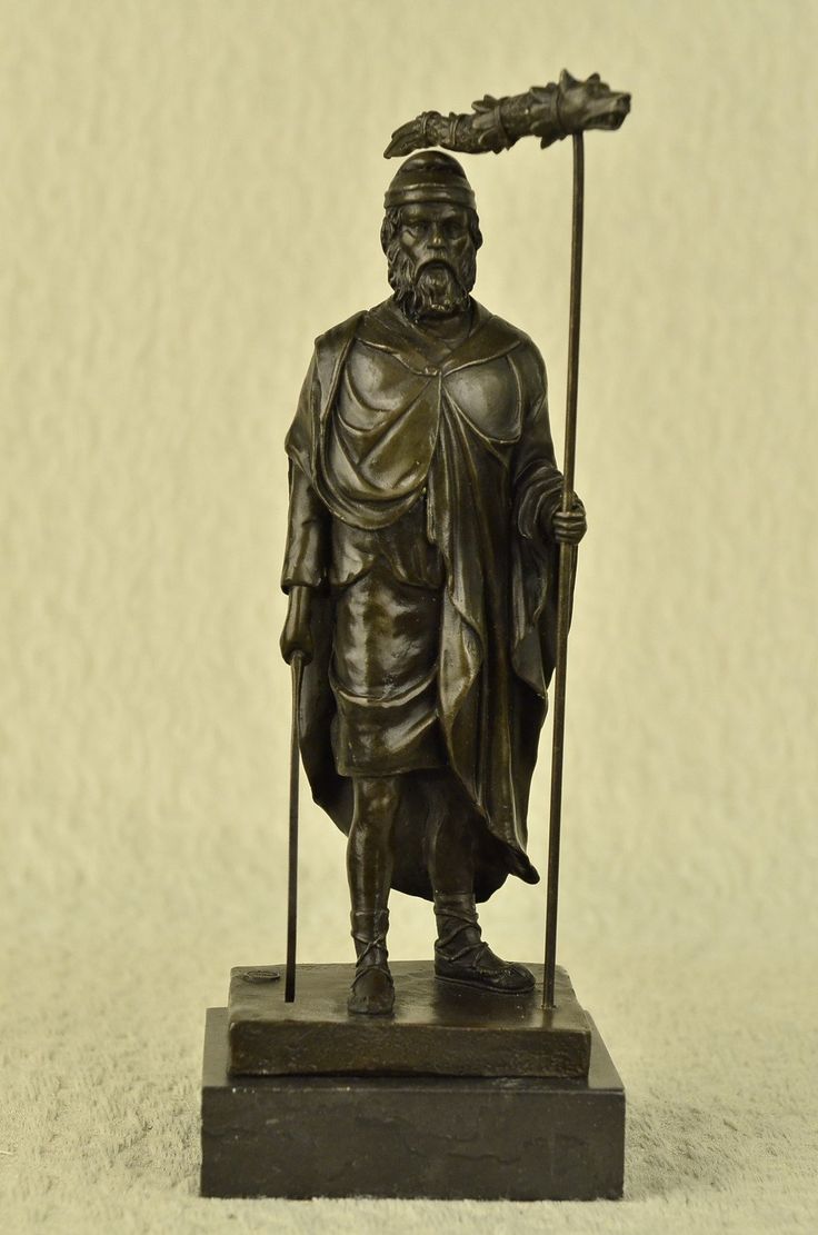 a bronze statue of a man holding a staff