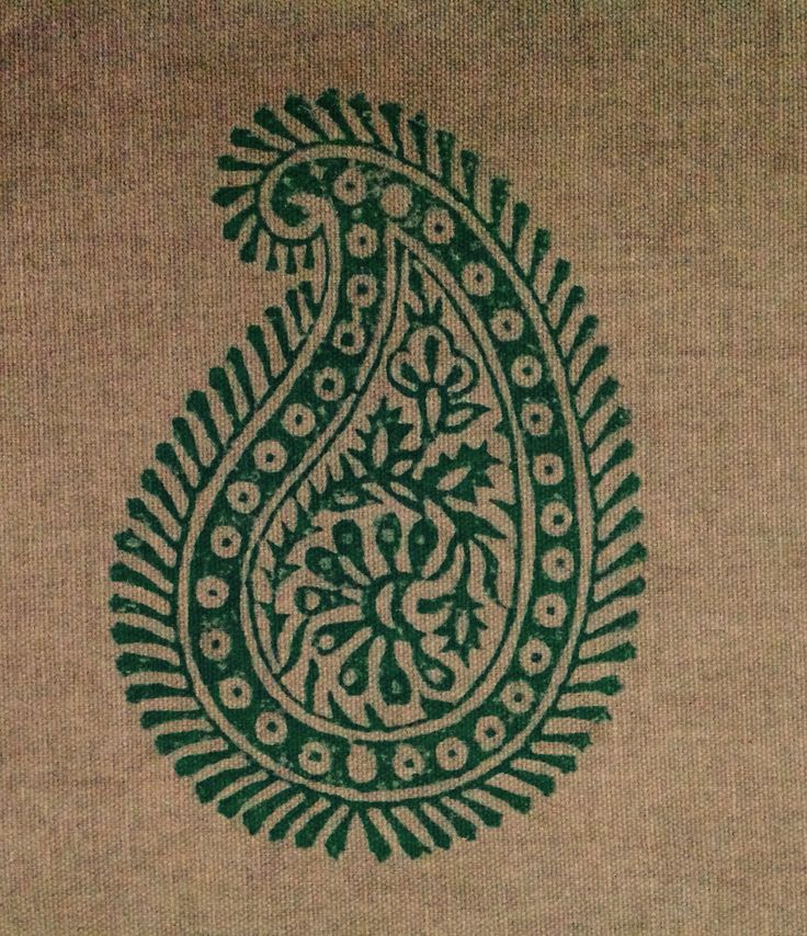 a green and white paisley design on a tan sweater with dark green trimmings