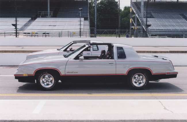 a silver car parked in front of an empty bleachers