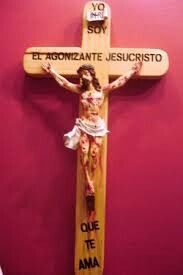 a wooden crucifix with words written on it in spanish and an image of jesus nailed to the cross