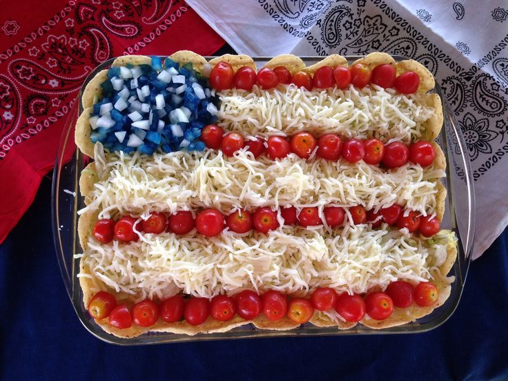 an american flag pizza with tomatoes, onions and cheese