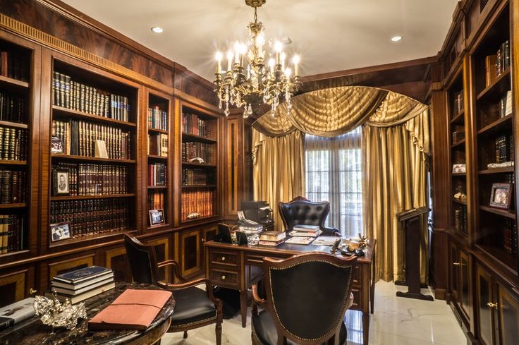 an elegant library with wooden bookshelves and chandelier