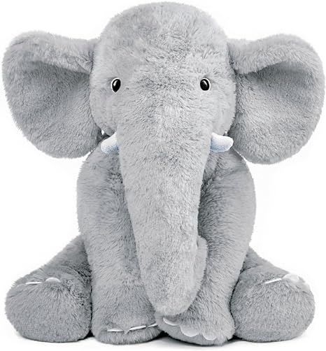 an elephant stuffed animal sitting on top of a white surface with its trunk up and eyes closed